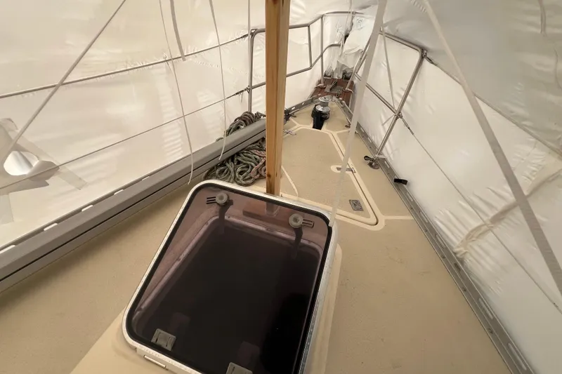 Slide: The Image of 1996 Caliber 35 LRC sailboat deck under protective cover, featuring ropes and hatch. - 17