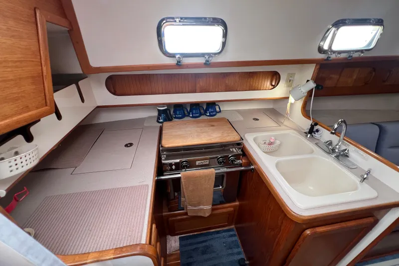 Slide: The Image of 1996 Caliber 35 LRC yacht kitchen with stove, sink, and wooden cabinetry. - 20