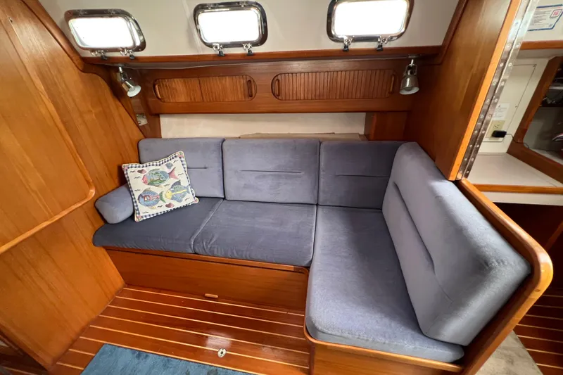 Slide: The Image of Cozy interior of 1996 Caliber 35 LRC sailboat with blue cushions and decorative pillow. - 29