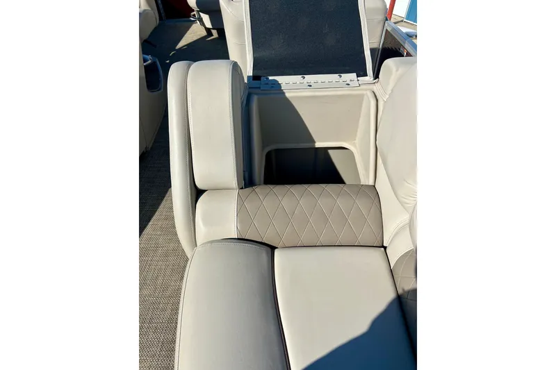 Slide: The Image of 2016 Bennington R21 boat interior with beige leather seating and storage compartment. - 11