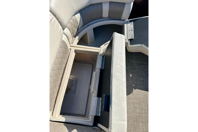 Slide: The Image of 2016 Bennington R21 boat seat storage compartment open, revealing interior space. - 18