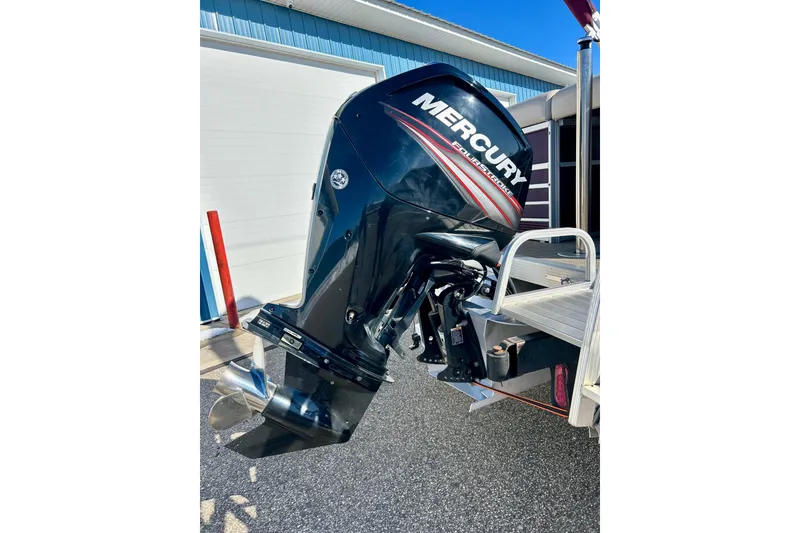 Slide: The Image of 2016 Bennington R21 with Mercury outboard motor, parked near a blue building. - 19