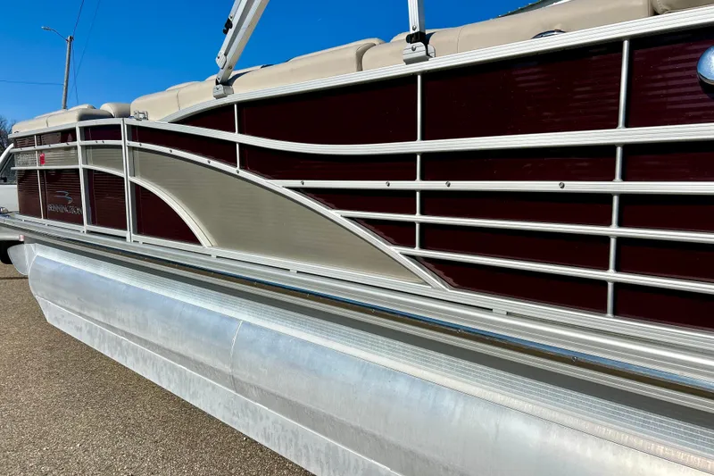 Slide: The Image of 2016 Bennington R21 pontoon boat with sleek maroon and beige design. - 29