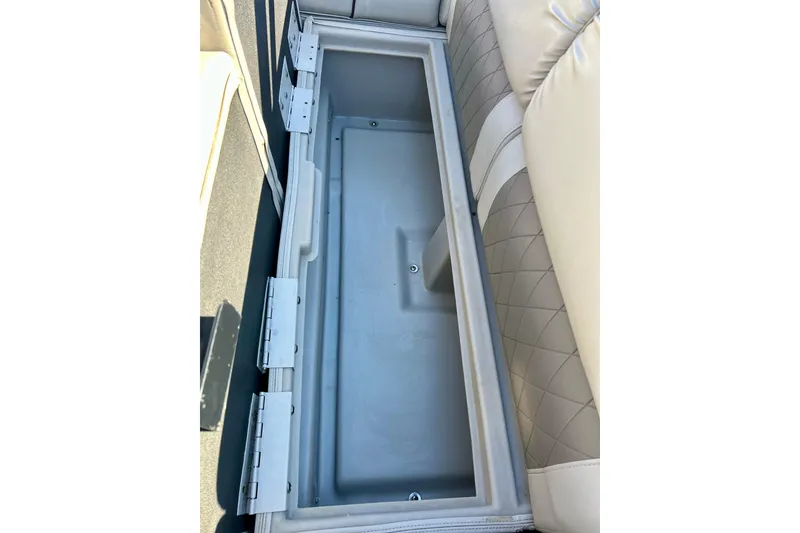 Slide: The Image of 2016 Bennington R21 boat storage compartment with cushioned seating and diamond-pattern upholstery. - 49