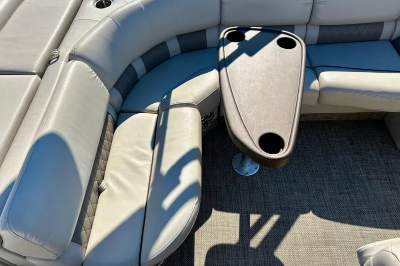 Slide: The Image of 2016 Bennington R21 boat interior with cushioned seating and table with cup holders. - 50