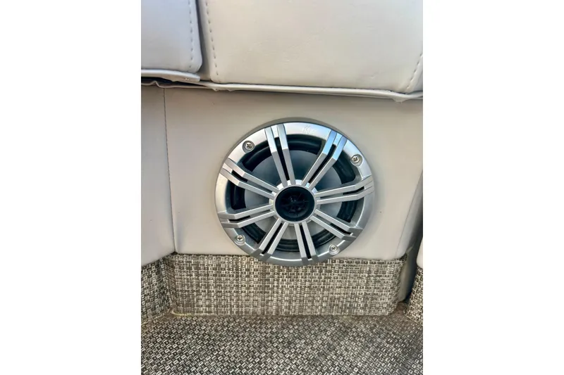 Slide: The Image of Speaker on 2016 Bennington R21 boat interior, featuring silver grille and textured flooring. - 56