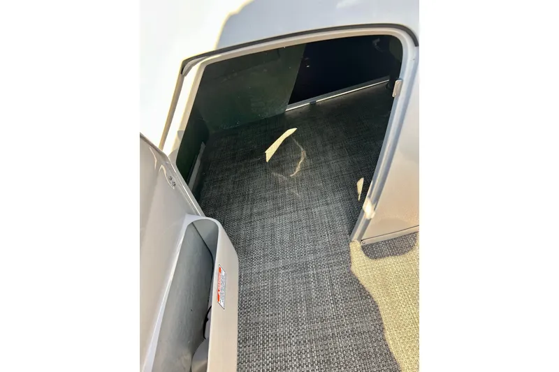 Slide: The Image of 2016 Bennington R21 boat interior storage compartment with carpeted flooring. - 59
