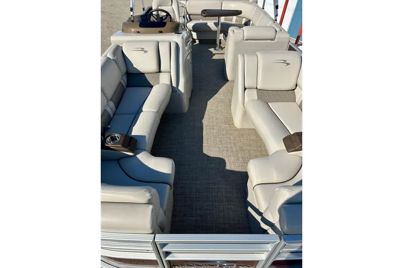 Slide: The Image of 2016 Bennington R21 pontoon boat interior with beige seating and steering console. - 7