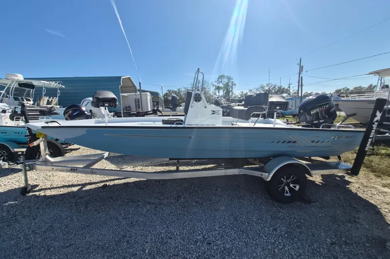 The Image of 2026 Xpress H20B Bay boat on trailer under clear blue sky. - 1