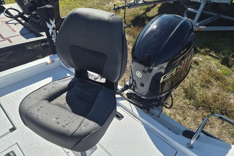 Slide: The Image of 2026 Xpress H20B Bay boat seat and Yamaha outboard motor, wet with water droplets. - 4