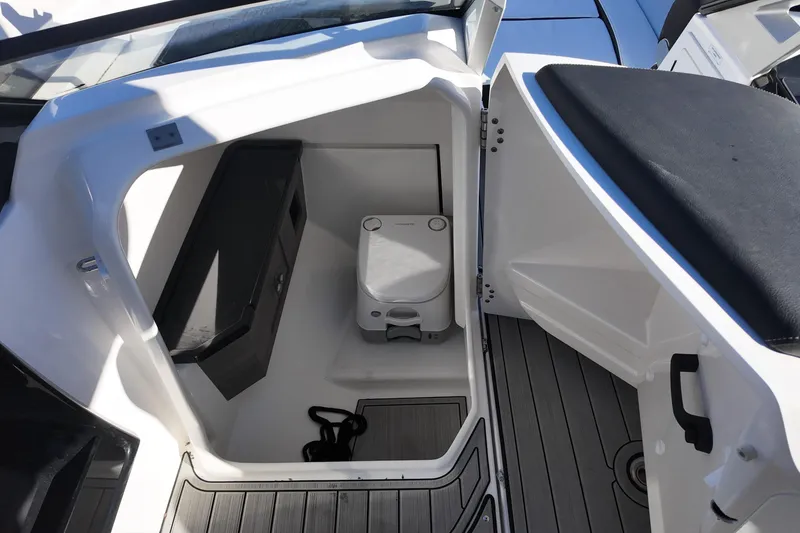 Slide: The Image of 2024 Yamaha Boats 275SE interior with compact marine toilet and storage. - 14