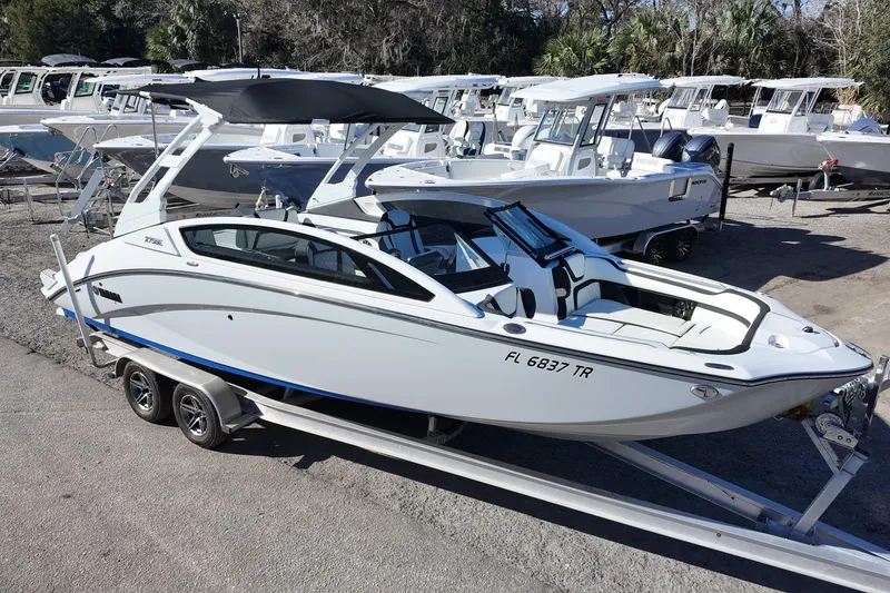 Slide: The Image of 2024 Yamaha Boats 275SE on trailer, sleek design, parked outdoors. - 2