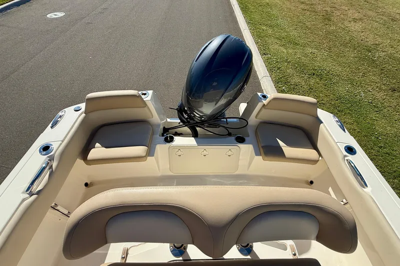 Slide: The Image of 2026 Scout 195 Sportfish boat interior with cushioned seating and outboard motor. - 11