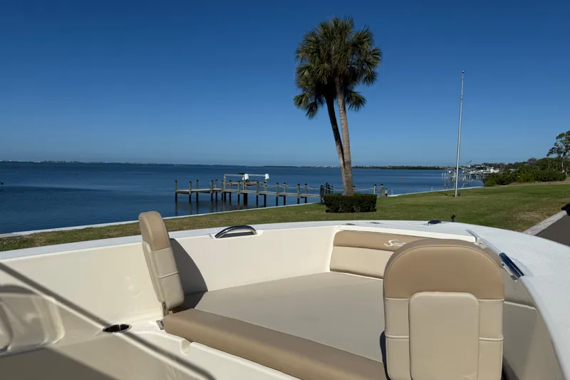 Slide: The Image of 2026 Scout 195 Sportfish boat with scenic waterfront view and palm tree. - 24