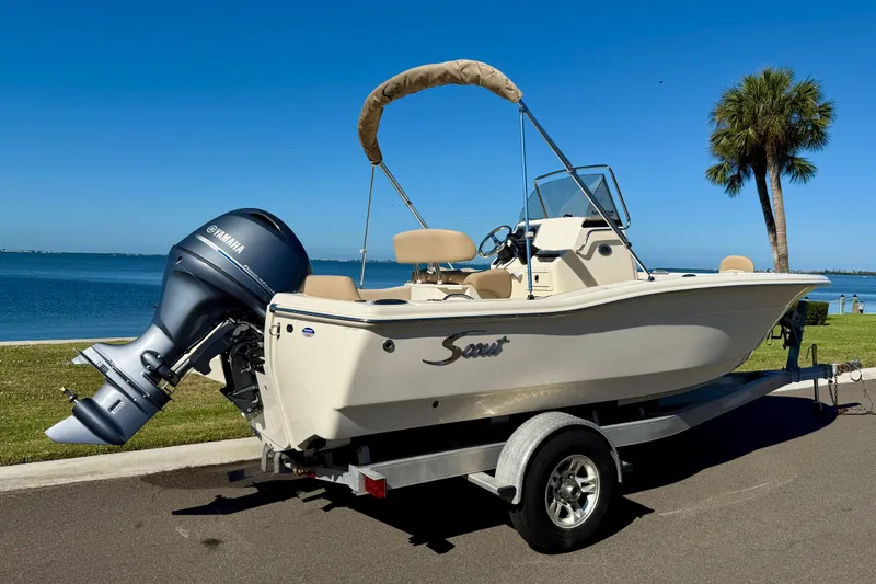 Slide: The Image of 2026 Scout 195 Sportfish boat on trailer by waterfront, featuring Yamaha outboard motor. - 3