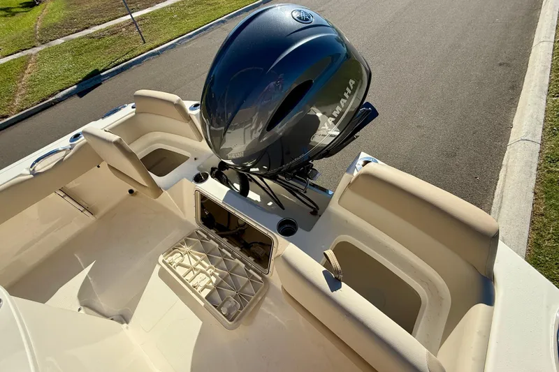Slide: The Image of 2026 Scout 195 Sportfish boat interior with Yamaha engine, beige seating, and storage compartments. - 8