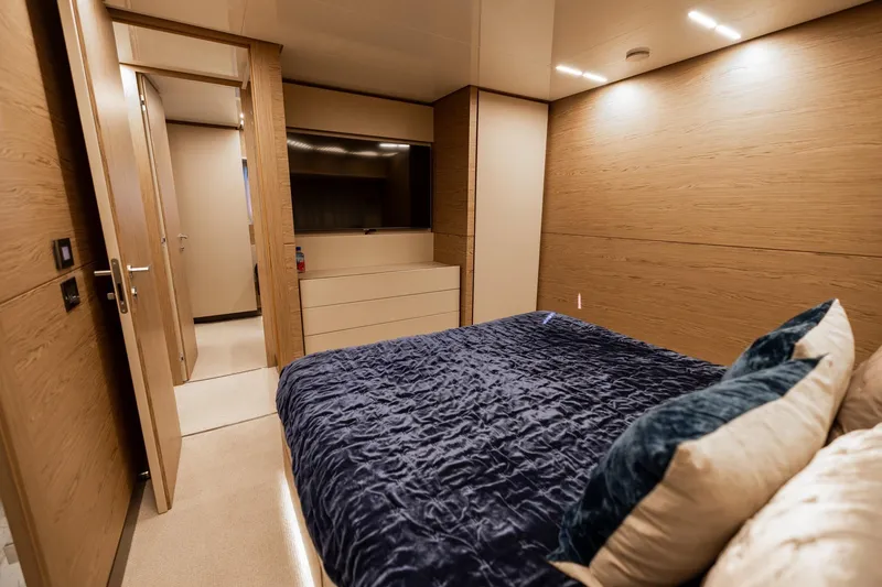 Slide: The Image of Luxurious bedroom interior of 2021 Ferretti Yachts 920 with modern wood paneling. - 25