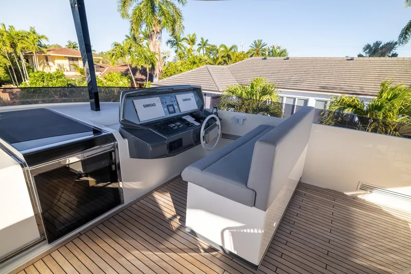 Slide: The Image of Flybridge of 2021 Ferretti Yachts 920 with modern controls and seating, surrounded by palm trees. - 33