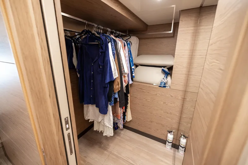 Slide: The Image of Walk-in closet on 2021 Ferretti Yachts 920, featuring hanging clothes and storage shelves. - 19