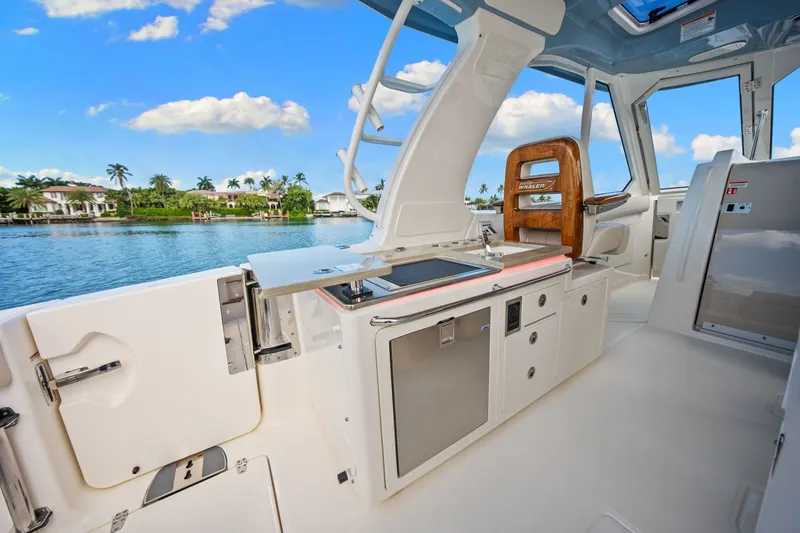 Slide: The Image of The image shows the cockpit of a 2026 Boston Whaler 380 Realm with a modern kitchenette. - 48