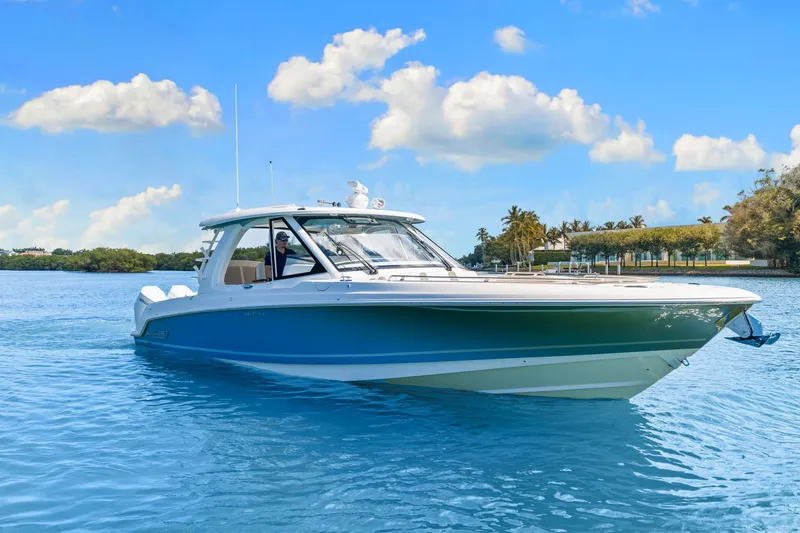 Slide: The Image of A 2026 Boston Whaler 380 Realm on calm water under a blue sky. - 13