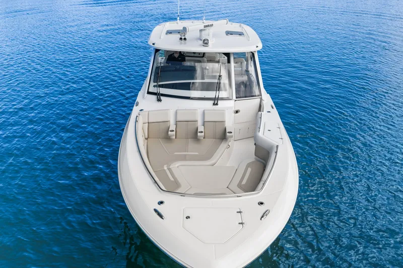 Slide: The Image of Boston Whaler 380 Realm 2026 on calm water, featuring a spacious foredeck and sleek cabin. - 4