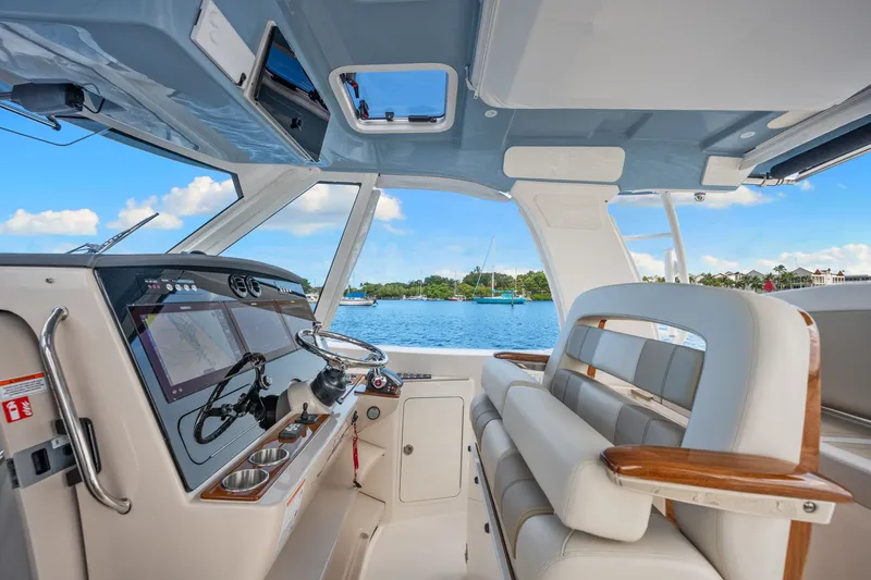 Slide: The Image of The cockpit of the 2026 Boston Whaler 380 Realm features modern navigation and luxurious seating. - 35