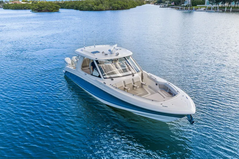 Slide: The Image of 2026 Boston Whaler 380 Realm on calm water, featuring a blue hull and spacious deck. - 5