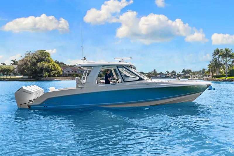 Slide: The Image of Boston Whaler 380 Realm 2026 on calm water with blue sky and palm trees in the background. - 14