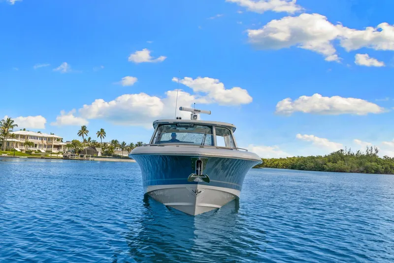 Slide: The Image of 2026 Boston Whaler 380 Realm on calm water with blue sky and palm trees in the background. - 7