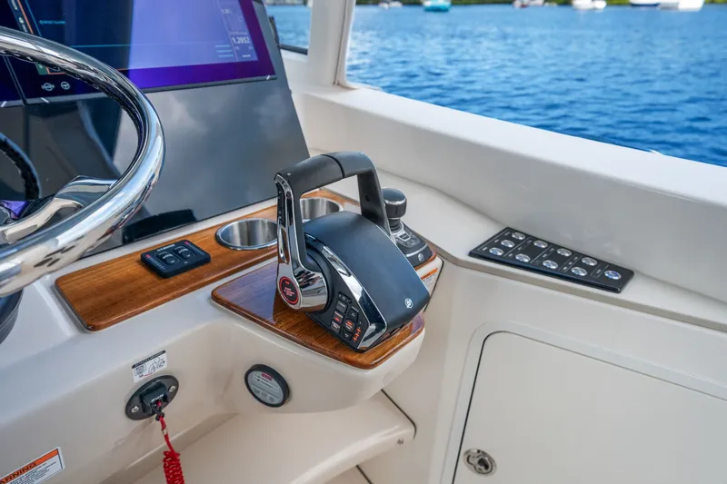 Slide: The Image of Helm of the Boston Whaler 380 Realm with modern controls and a view of the water. - 36