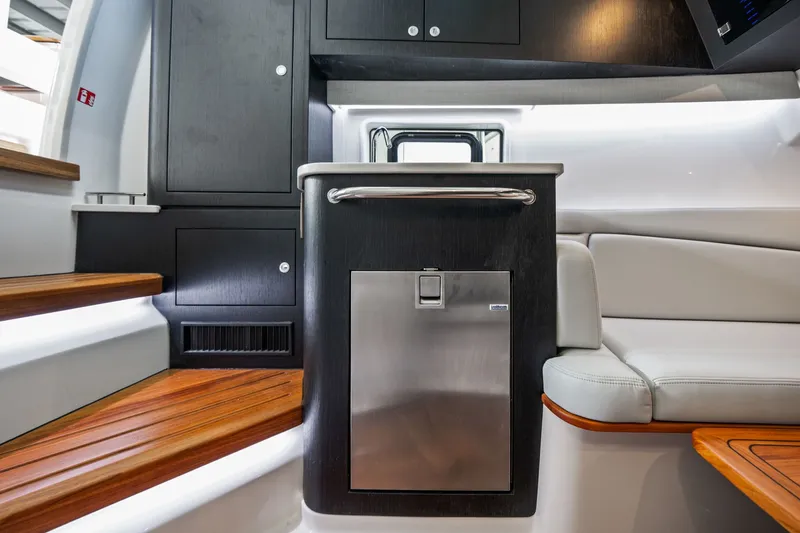 Slide: The Image of Interior of the Boston Whaler 380 Realm with sleek wood flooring and modern cabinetry. - 26