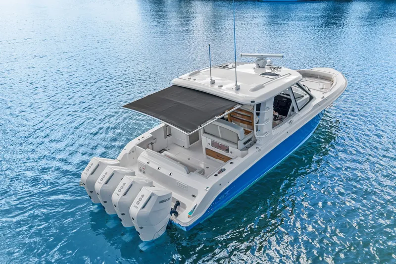 Slide: The Image of A modern 2026 Boston Whaler 380 Realm on calm water with three outboard engines. - 11