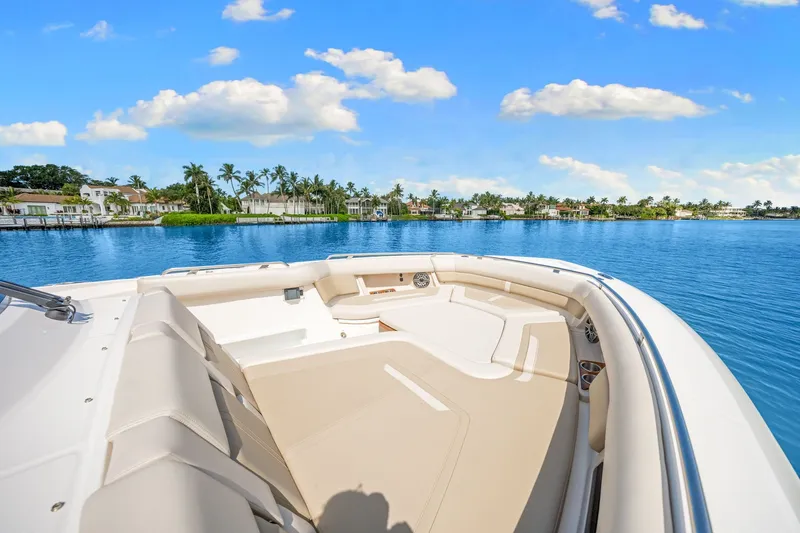 Slide: The Image of Boston Whaler 380 Realm 2026: Spacious deck with comfortable seating, surrounded by calm water and palm trees. - 21