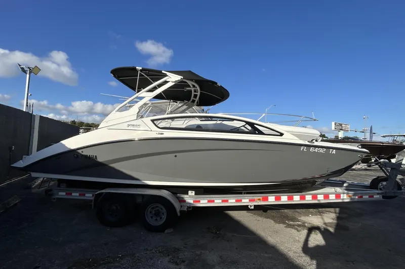 The Image of 2021 Yamaha Boats 275SE on trailer under clear blue sky. - 1