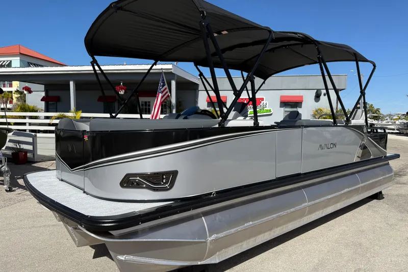 The Image of 2026 Avalon 2385 LSZ Rear Fish Tri Toon boat with high performance features, docked outdoors. - 1