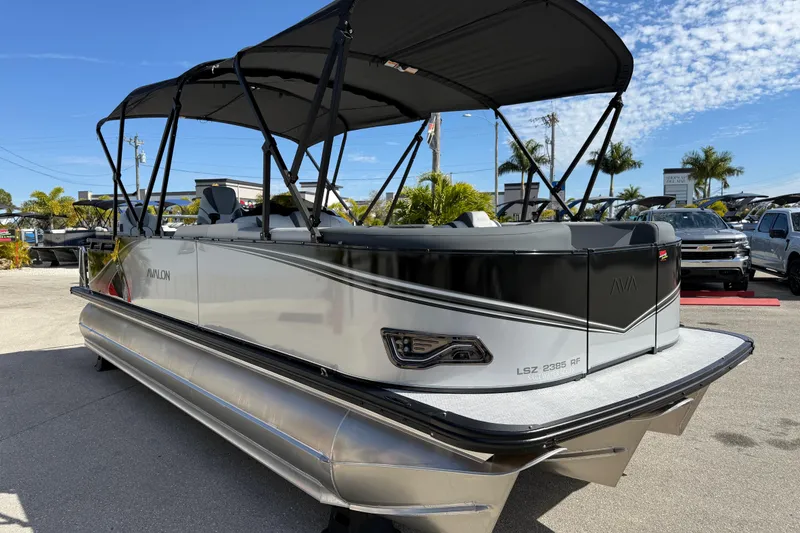 Slide: The Image of 2026 Avalon 2385 LSZ Rear Fish Tri Toon boat with high performance features, parked outdoors. - 5