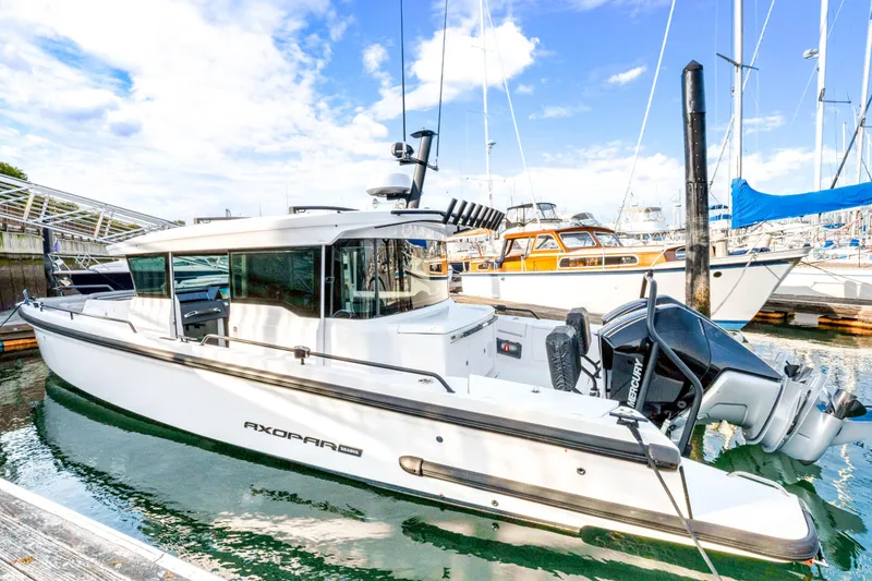 The Image of 2021 Axopar 37 XC Cross Cabin boat docked in a marina under a blue sky. - 0
