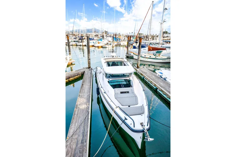 Slide: The Image of 2021 Axopar 37 XC Cross Cabin docked in a marina, surrounded by sailboats. - 11