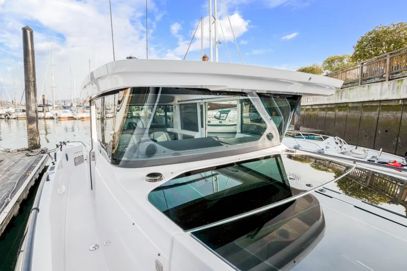 Slide: The Image of 2021 Axopar 37 XC Cross Cabin boat docked at marina under blue sky. - 16