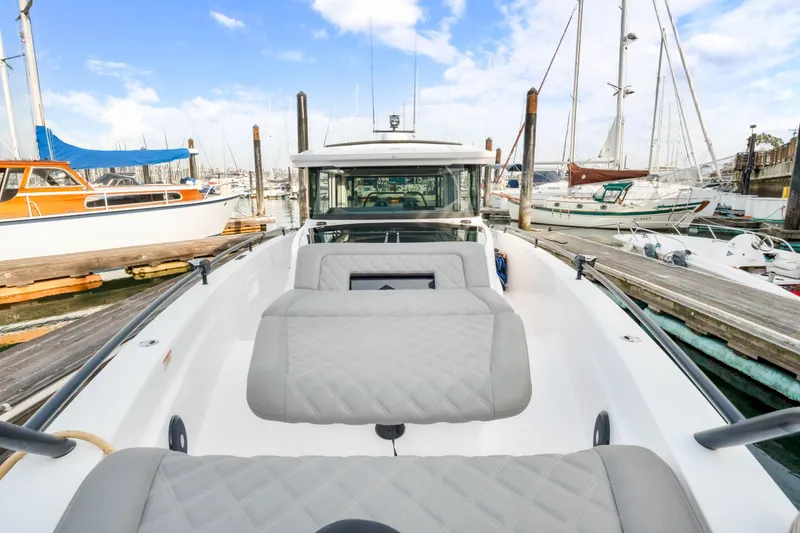 Slide: The Image of 2021 Axopar 37 XC Cross Cabin boat docked in a marina with sailboats. - 17