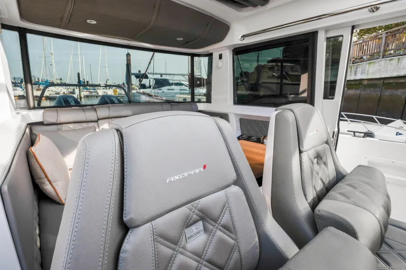 Slide: The Image of Interior of 2021 Axopar 37 XC Cross Cabin with luxurious seating and marina view. - 18