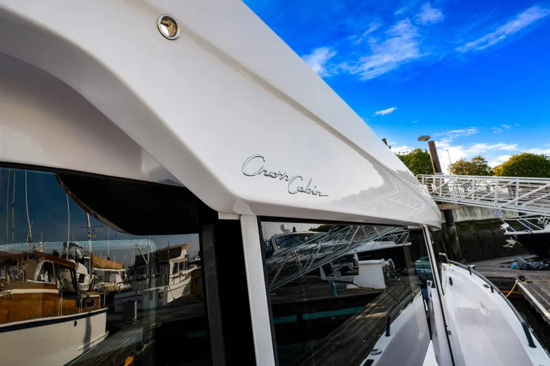 Slide: The Image of 2021 Axopar 37 XC Cross Cabin boat docked under a clear blue sky. - 24