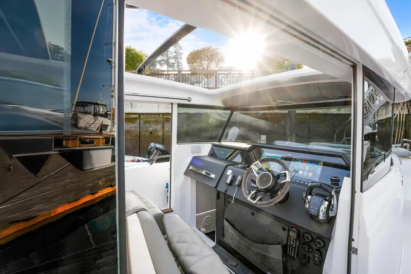 Slide: The Image of 2021 Axopar 37 XC Cross Cabin interior with modern dashboard and steering wheel. - 25