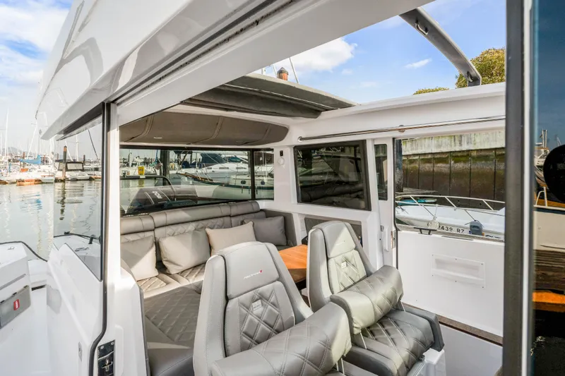 Slide: The Image of 2021 Axopar 37 XC Cross Cabin interior with luxurious seating and marina view. - 29