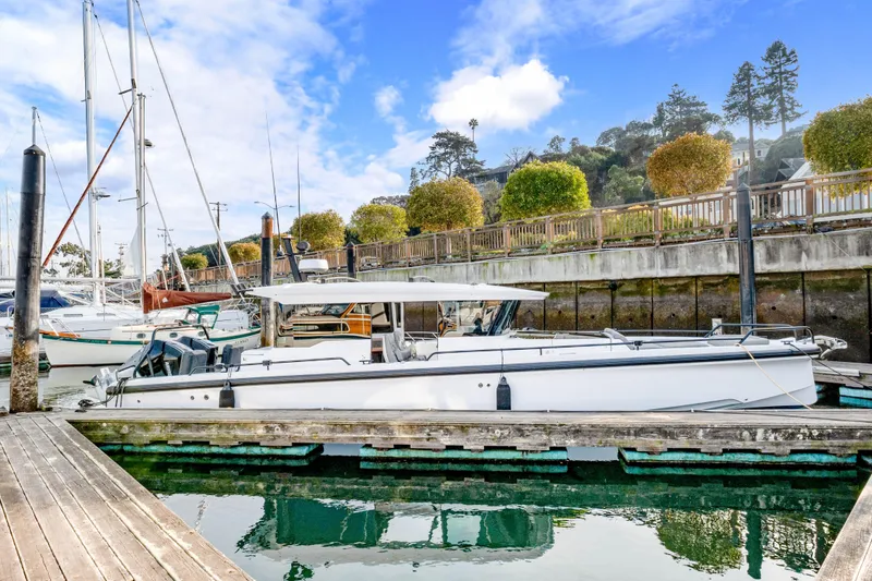 Slide: The Image of 2021 Axopar 37 XC Cross Cabin docked at a marina with scenic background. - 3