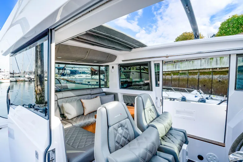 Slide: The Image of 2021 Axopar 37 XC Cross Cabin interior with luxurious seating and marina view. - 34