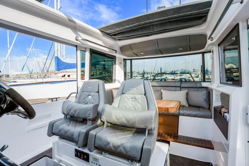 Slide: The Image of Interior of 2021 Axopar 37 XC Cross Cabin with luxurious seating and marina view. - 45