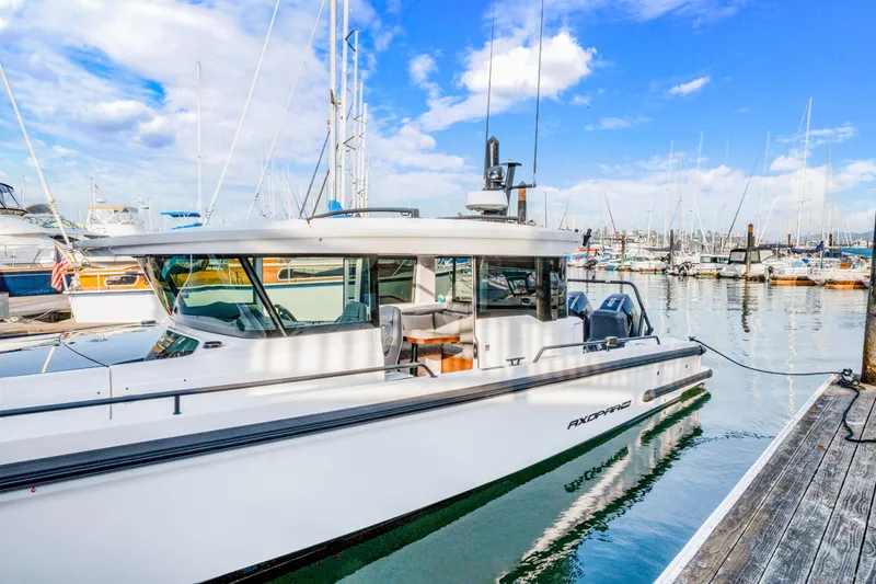 Slide: The Image of 2021 Axopar 37 XC Cross Cabin docked at a marina under a blue sky. - 7