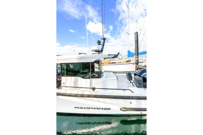 Slide: The Image of 2021 Axopar 37 XC Cross Cabin boat docked in marina under blue sky. - 9